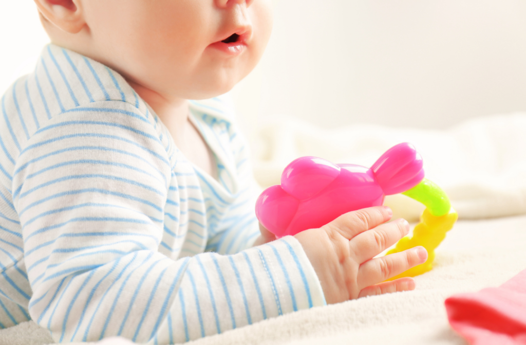 Fine motor development ages 0-12 months baby holding a rattle